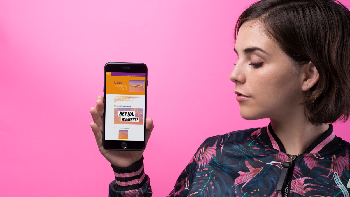 space-gray-iphone-mockup-of-a-young-woman-wearing-a-bomber-jacket-against-a-pink-wall-21847